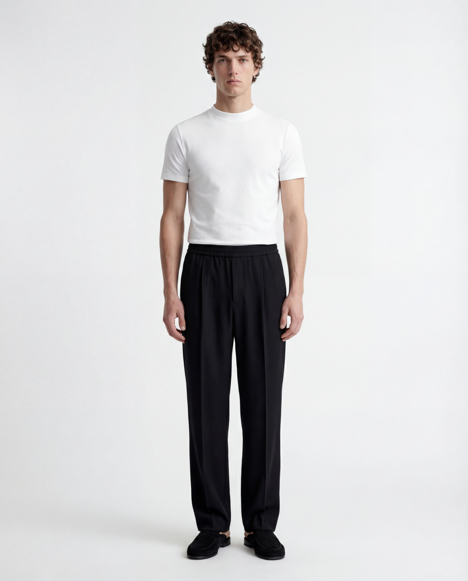Man wearing a white t-shirt and black pants on a white background